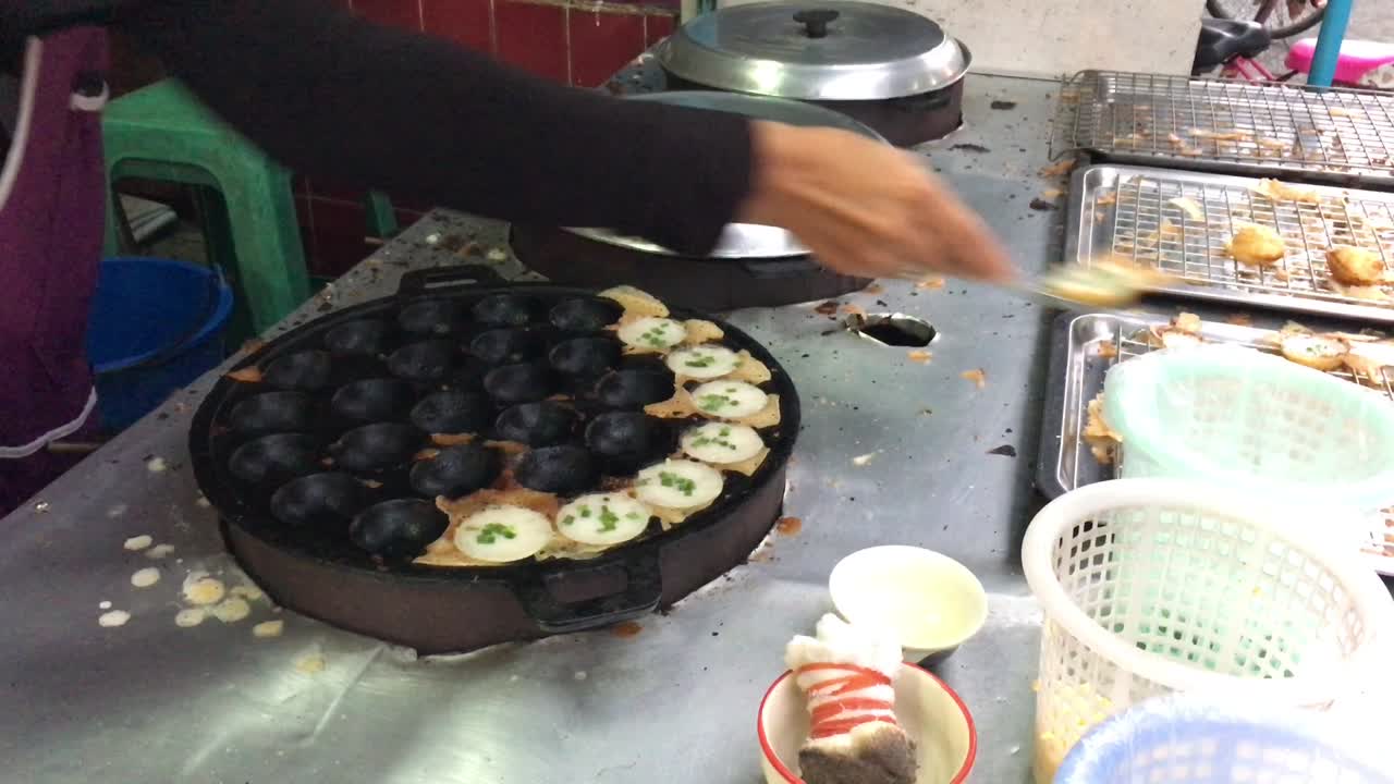 concepto de cocina. tipo de carne dulce tailandesa. leche de coco mezclada con postre frito en polvo en el mercado de comida callejera tailandés de la noche. postre de carne tradicional tailandesa, panqueque, pudín. imágenes de 4k.