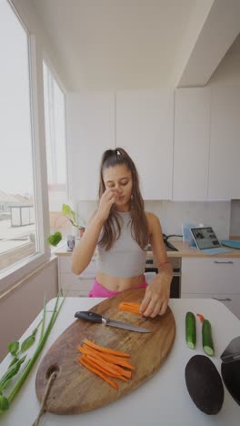 woman cutting carrots in a kitchen