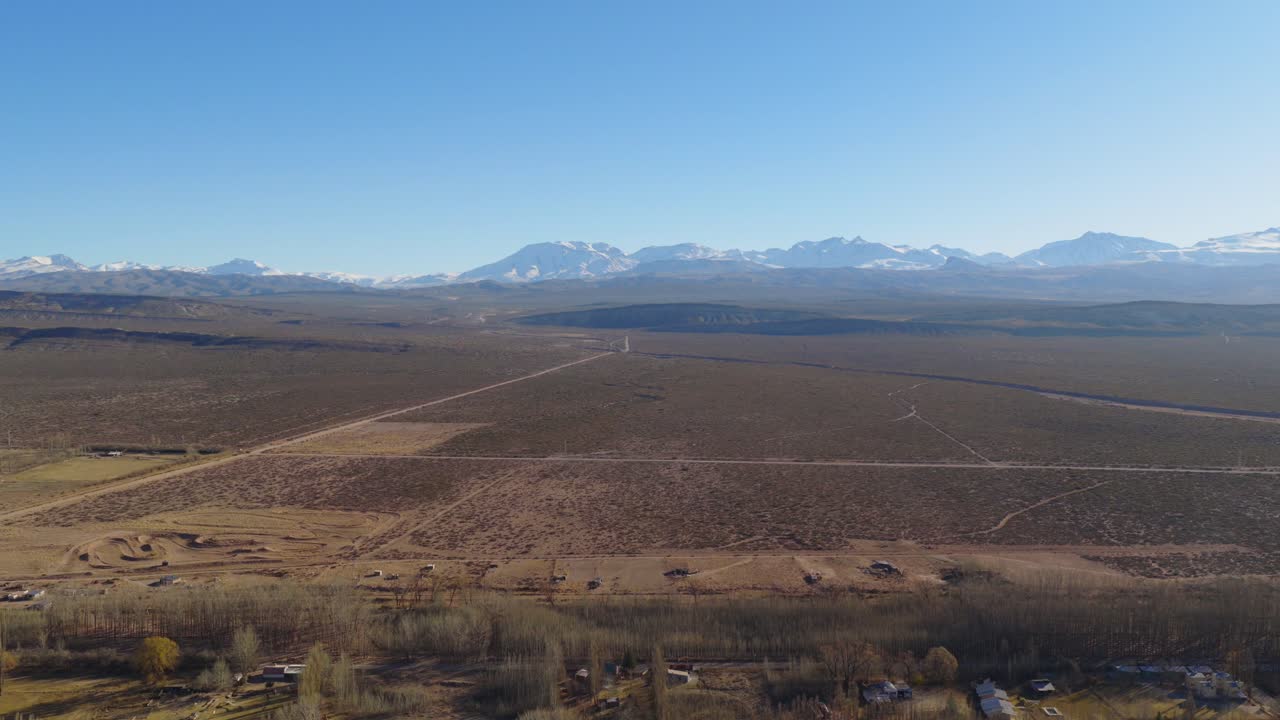 Drone view of the desert near Malargüe with snowy Andes mountains in the background.