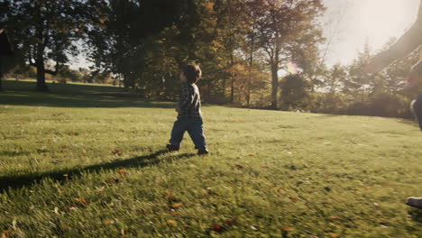 Mom-have-fun-with-her-baby---run-around-the-picturesque-lawn-at-sunset