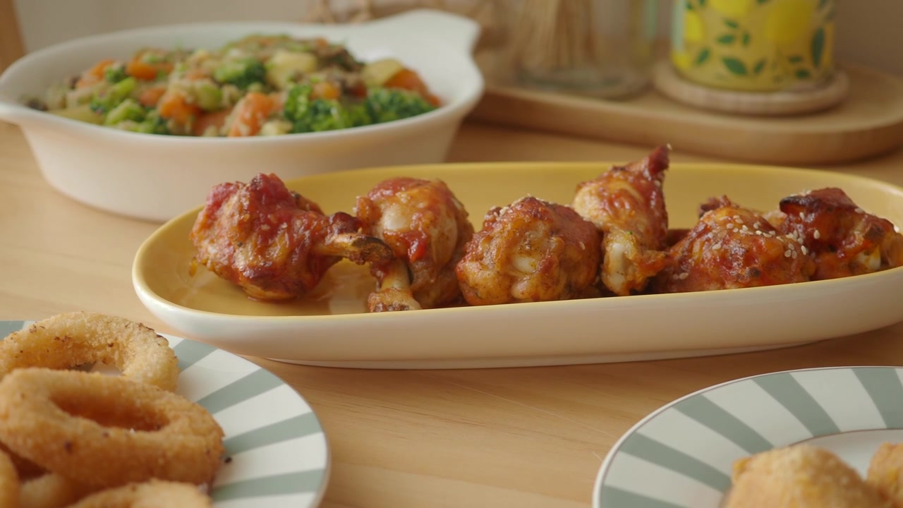 Appetitose alette di pollo glassate servite su un tavolo con vari contorni