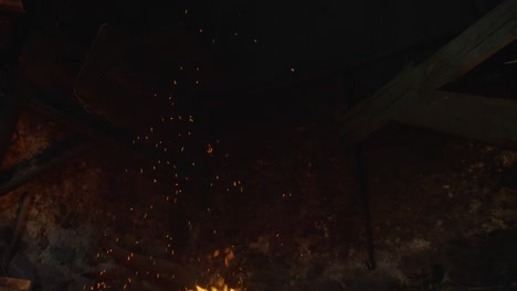 fire sparks and flame rising in a stone fireplace, slow motion