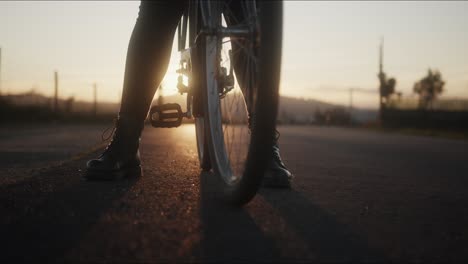 a women sits on a bicycle during sunset