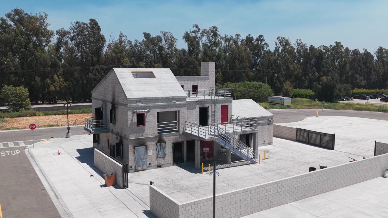 Aerial low close-up shot of a burn building used for firefighter training in Ventura County, California. 4K