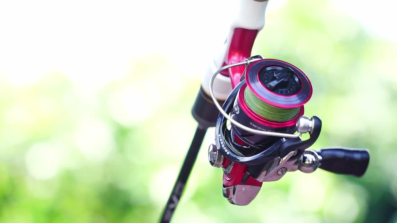 Primo piano di un mulinello da pesca su una canna con filo verde