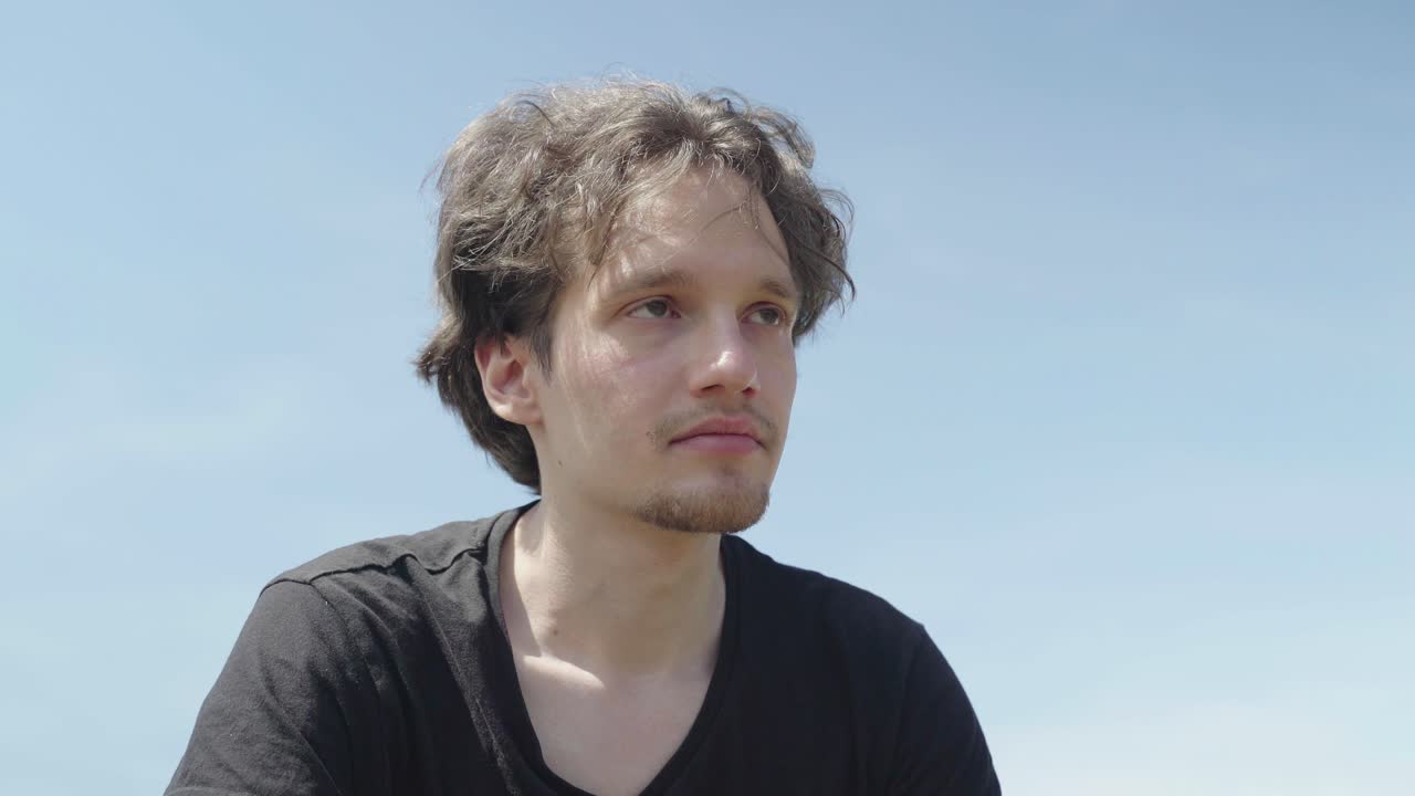 남자는 비트에 따라 머리를 움직이고 어리석은 다채로운 안경을 입고 웃습니다.