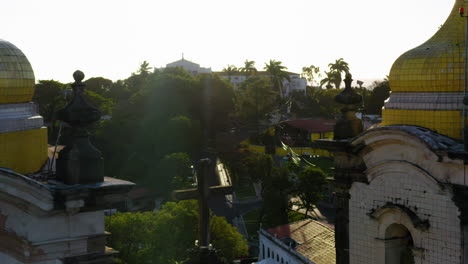 Vista-Aérea-De-La-Cima-De-La-Iglesia-Nosso-Senhor-Do-Bonfim,-La-Ciudad-Alrededor-Y-El-Océano-Al-Fondo,-Salvador,-Bahía,-Brasil