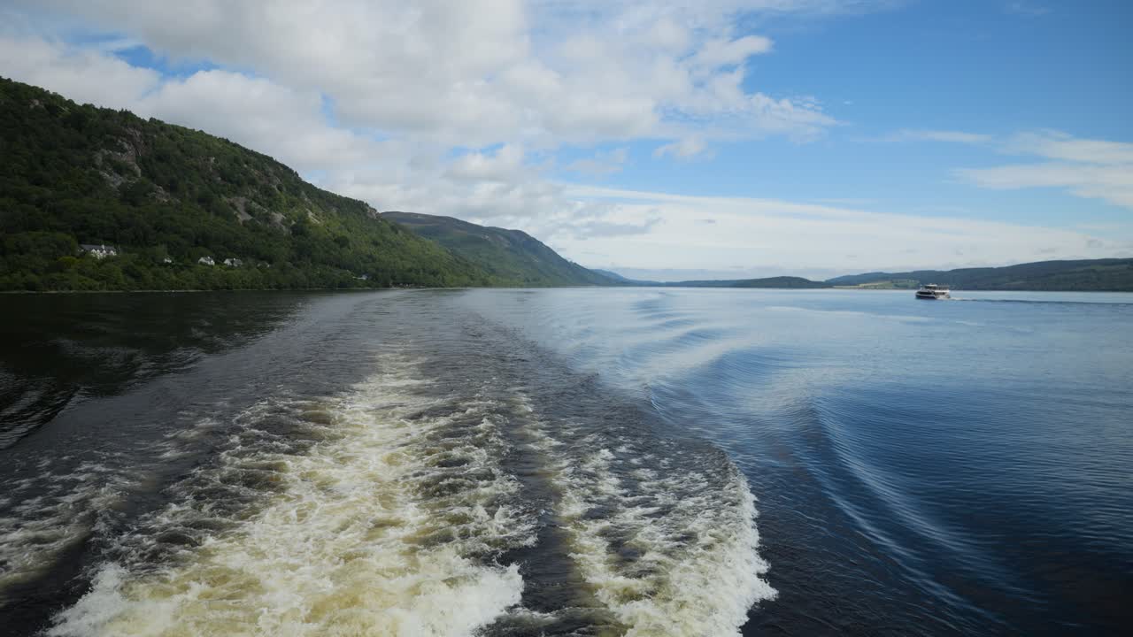 밝은 파란 하늘 아래 보트 트레일과 함께 스코틀랜드 호수의 조용한 풍경