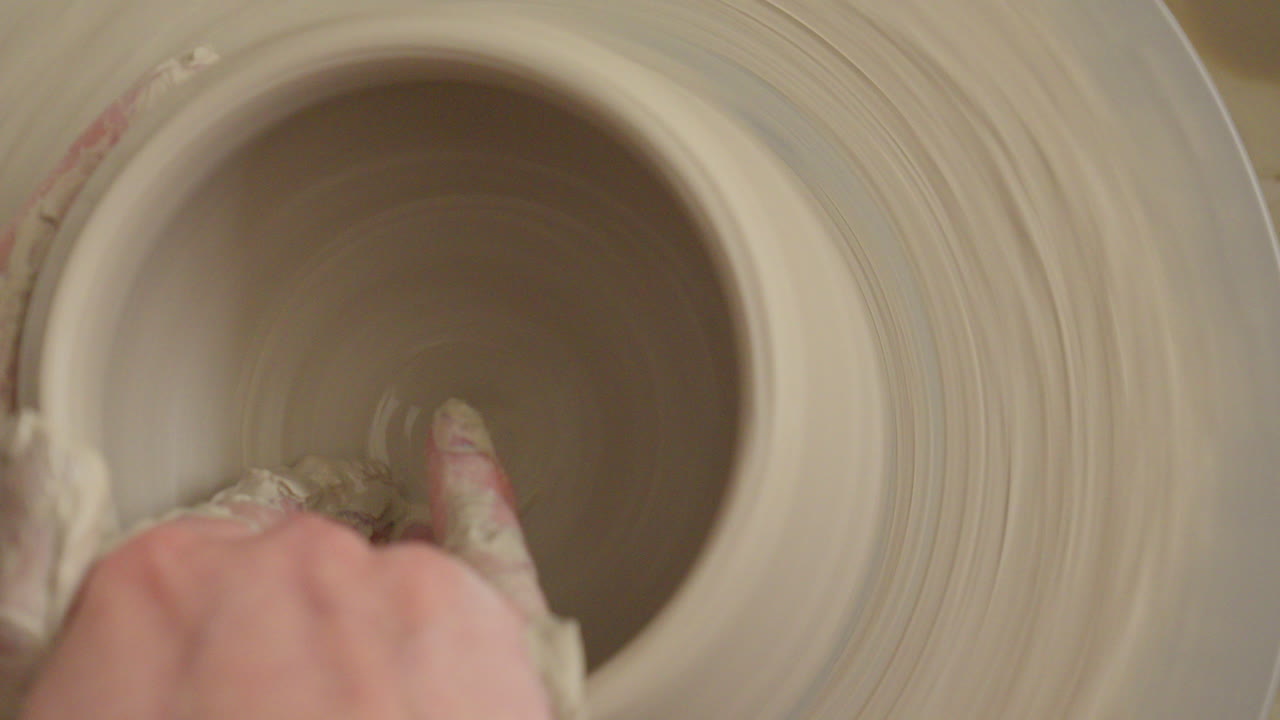 Pottery artist making a bowl on a throwing wheel