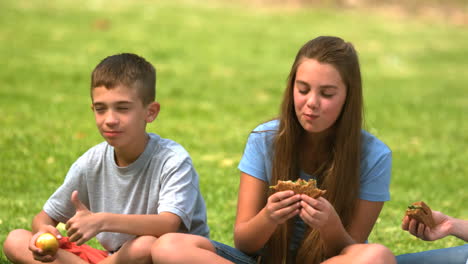 siblings eating a sandwich together