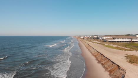 rising drone shot of resorts and hotels on the beach in oak island nc