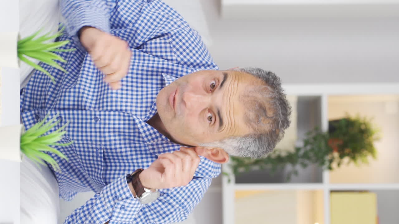 재미있는 남자가 카메라를 조롱하는 수직 비디오.