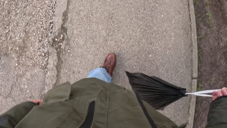 top down view of a man walking on the street and taking out trash. pov of garbage bag in the hands.