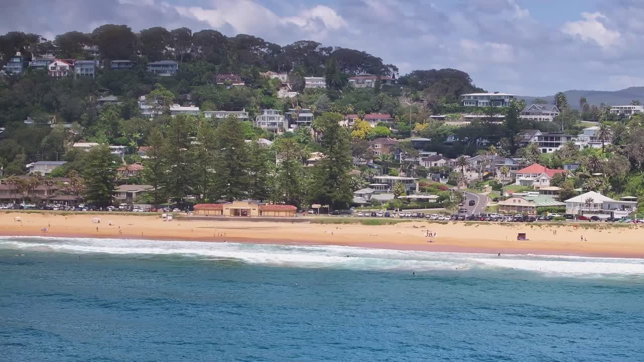 파름 해변을 따라 서핑을 뒤로 하고 해변 건물을 보여주는 공중