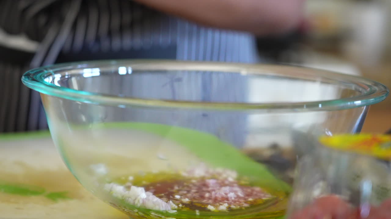 agregando chalotes picados en un tazón para hacer aderezo para ensaladas - serie de ensaladas antipasto