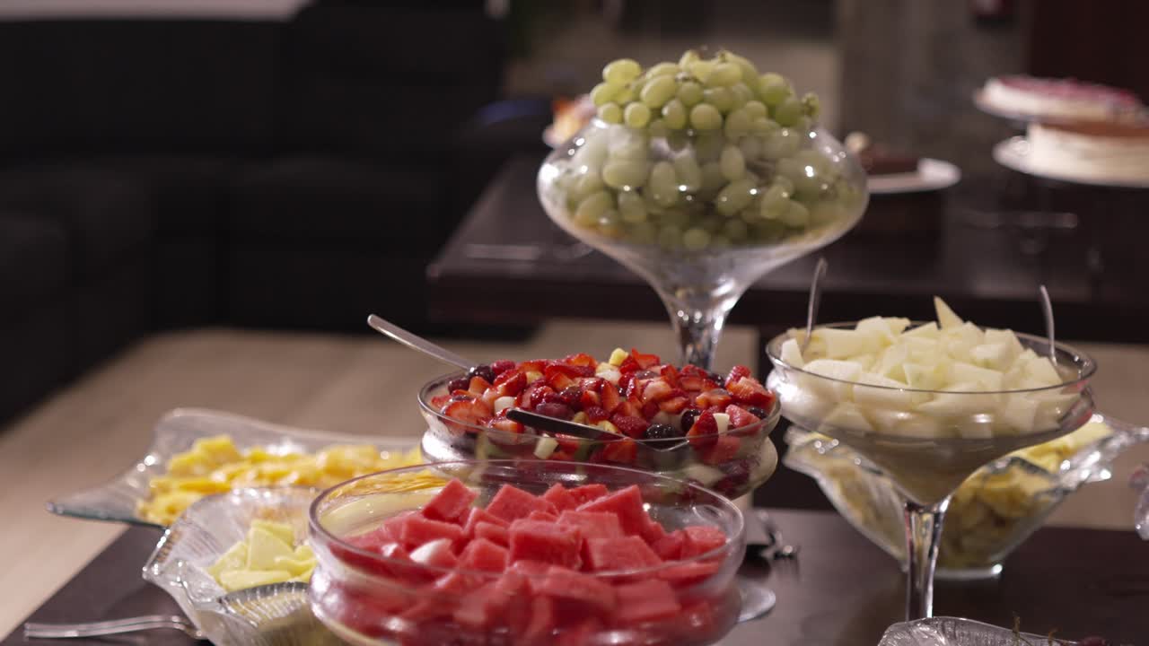 Assorted fresh fruit including watermelon, grapes, and melon in glass bowls