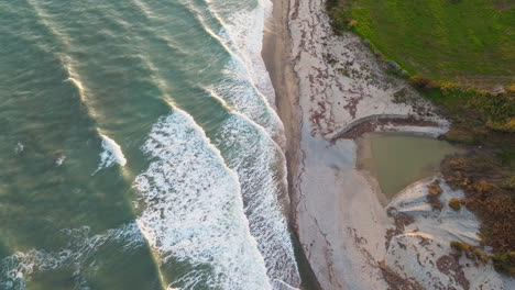 ocean waves and mouth of a dry small river after a storm