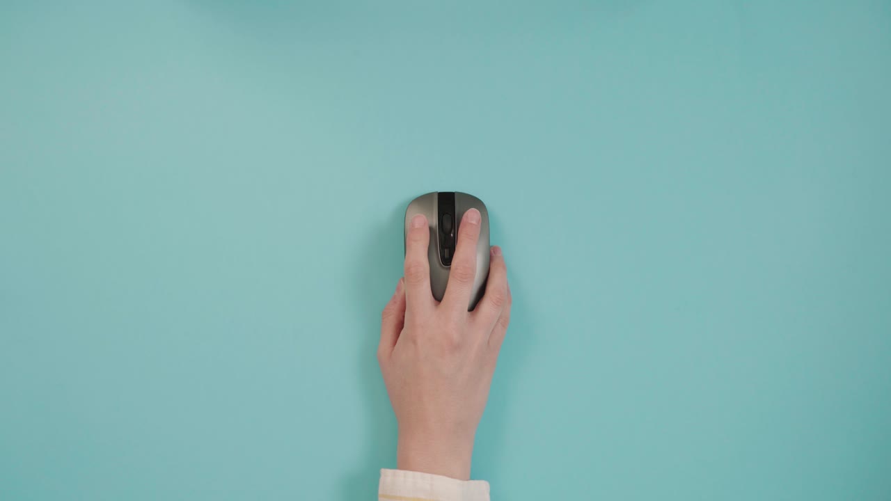 persona de la cosecha usando el ratón inalámbrico en la mesa azul