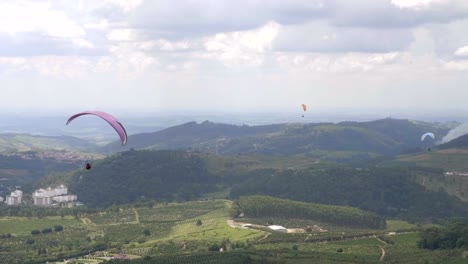 Gruppe-Von-Gleitschirmfliegern,-Die-Dem-Tal-In-Die-Ferne-Folgen