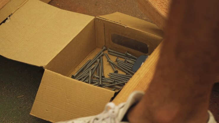 Picking up wood screw from box, Close Up