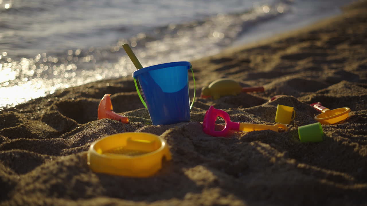 Beach toys on the sand at sunset