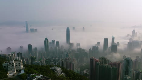 coastal fog over downtown hong kong as tall skyscrapers rise above the fog