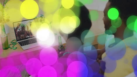 couple sharing virtual tech meeting in cozy living room, with animated shamrock confetti floating