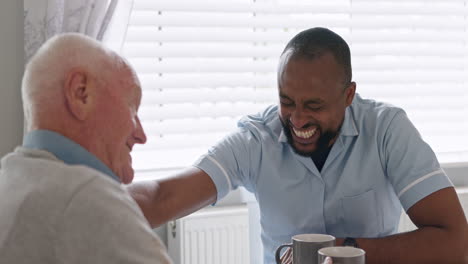 caregiver and elderly man sharing a laugh