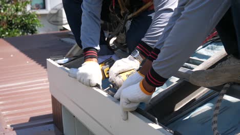 asian worker doing roof tiles installation, cutting, measuring process, close up