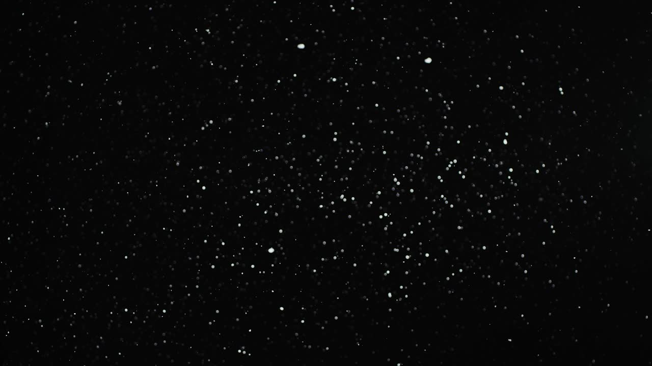 Slowly Falling Small Snowflakes Isolated on the Black Background on the Loop. Bokeh white Particles Fall. Real Lens Flare that is Easy to Use in Blend / Overlay Modes.