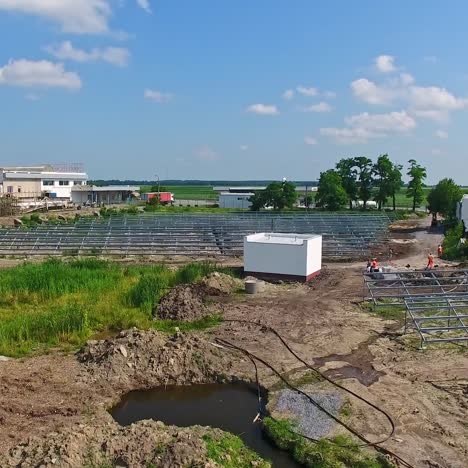 field with metal construction for solar panels. building of a new solar power plant among nature. motion camera back.