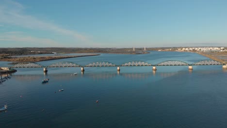 Aerial-of-old-classic-Portimao-train-bridge-and-Arade-River,-Algarve,-Portugal