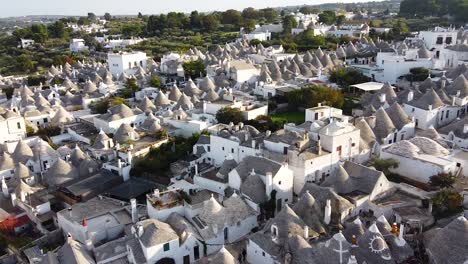 toma cinematográfica de drones acercándose a la antigua ciudad de alberobello, italia