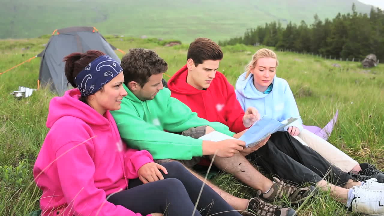 amigos en un viaje de campamento charlando juntos y leyendo el mapa