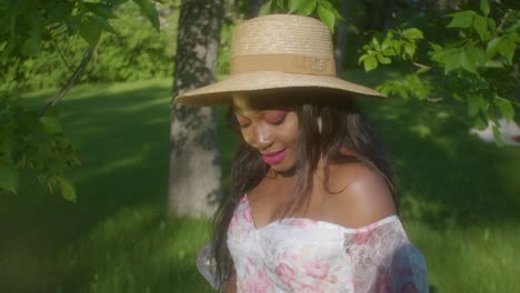 black woman adjusting hair on picnic in park circling