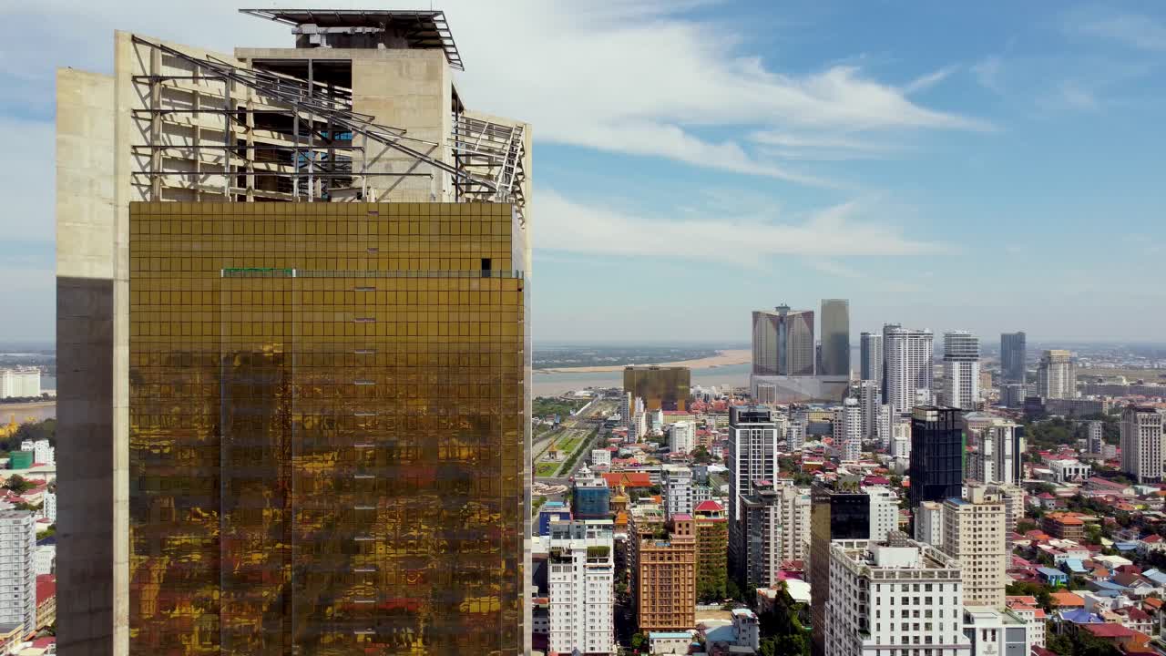 el dron revela la construcción de un rascacielos, la torre de oro 42 de phnom penh, la fachada de la pared de vidrio dorada, el paisaje urbano
