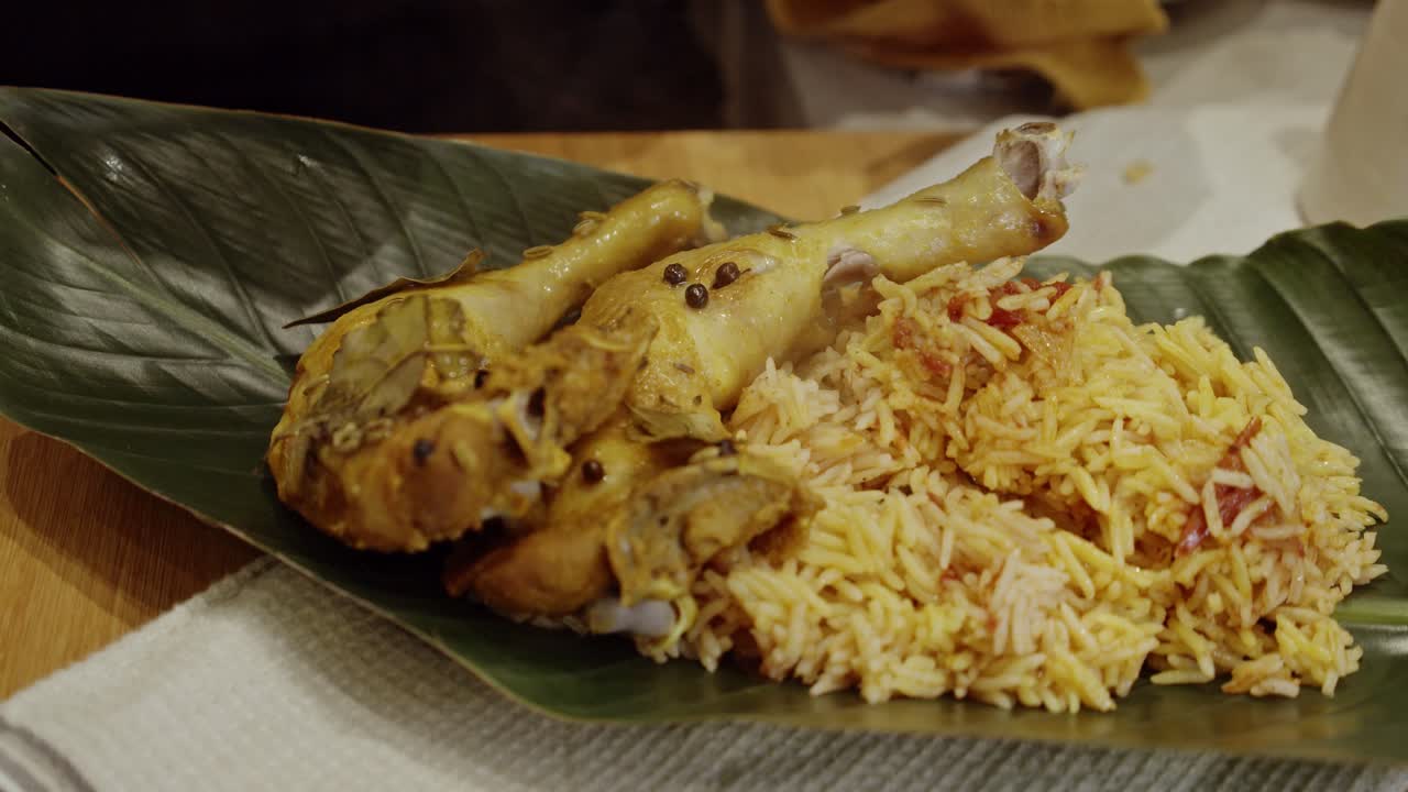 colocar muslos de pollo al vapor sobre arroz biriyani en una hoja de palmera