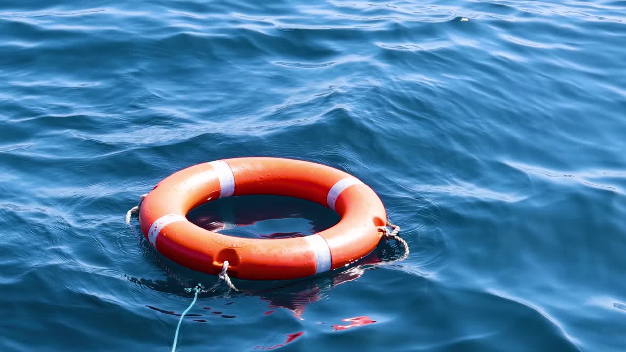 una boya salvavidas flota en las serenas olas del océano bajo la brillante luz del día, creando una escena marítima tranquila