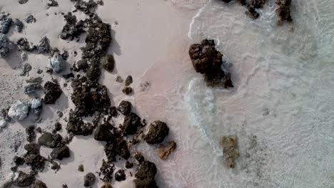 Antena-Baja,-Toma-De-Drones-De-Una-Playa-Blanca-Con-Rocas-Y-Pequeñas-Olas-Que-Se-Lavan-En-Tierra-En-El-Arrecife-Exterior-Del-Atolón-De-Fakarava,-Polinesia-Francesa