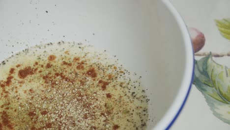 Adding-spices-to-butter-milk-inside-white-deep-plate