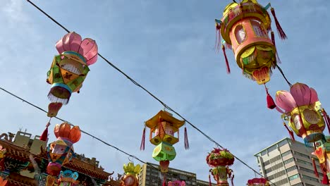 lanterns hanging near temple and skyscrapers