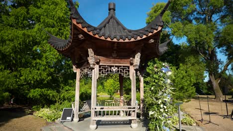 the outdoor seating shelter made from wood is beautifully embellished, providing a serene view in slow motion