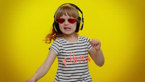 attractive blonde child kid listening music via headphones dancing disco fooling having fun party