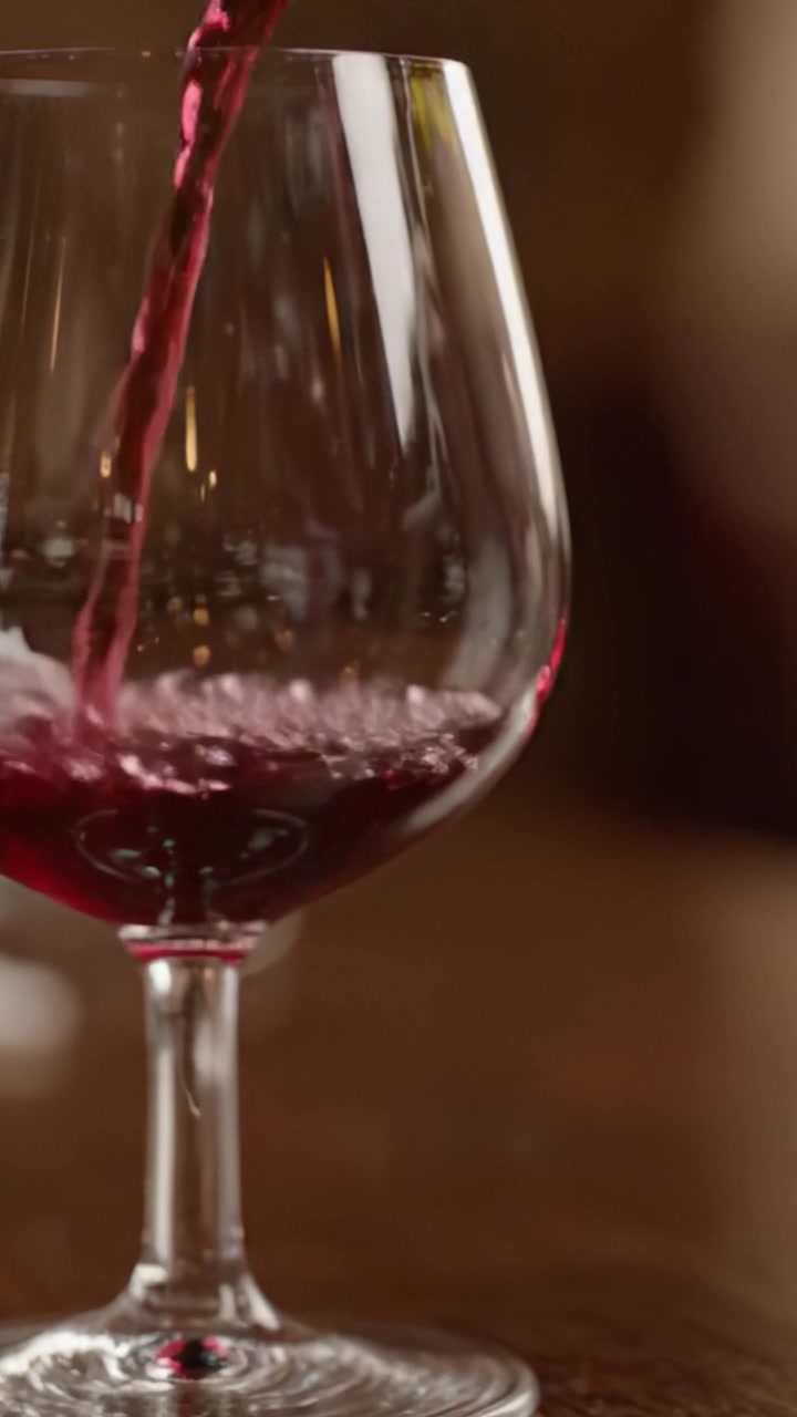 Una bella transizione da un bicchiere vuoto a un bicchiere pieno di vino rosso, che mostra l'eleganza e il colore ricco del buon vino in un ambiente raffinato.