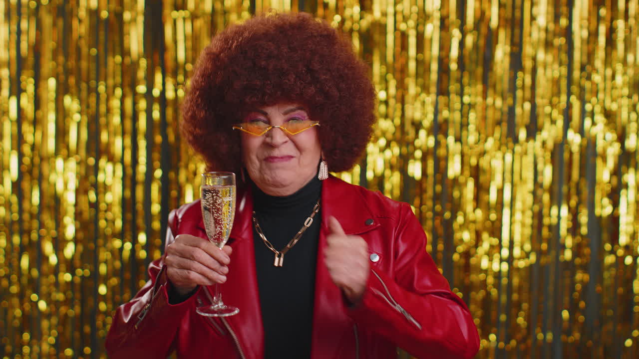 Anziana divertente che ascolta musica, sorride e balla musica da discoteca, bevendo champagne e divertendosi