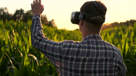 smart farming with iot futuristic agriculture concept : farmer wears vr or ar glasses while monitoring rainfall temeprature humidity soil ph with immersive experience on digital holographic screen.