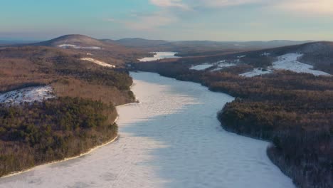 Flying-down-and-forward-towards-a-frozen-lake-with-the-long-shadows-of-early-morning