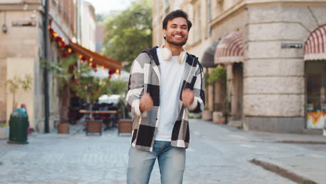 excited happy man traveler shouting celebrating success winning clenching fists standing on street