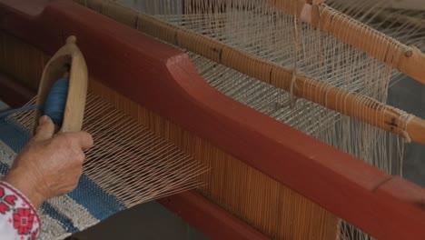 weaver makes fabric in ethnic loom