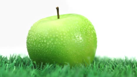 Green-apple-on-grass-rotating-